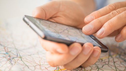 Close-up of hand using smartphone over map