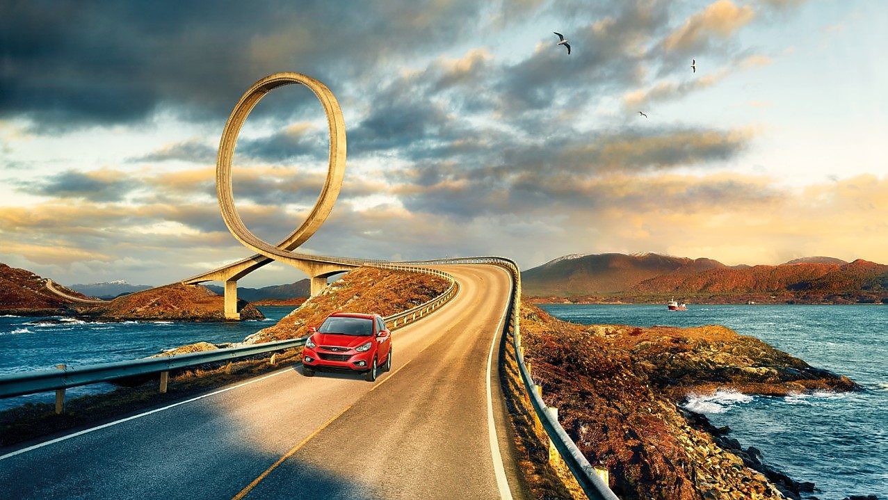 紅色汽車在河畔行駛