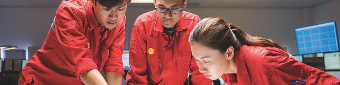 Three employees reviewing plans