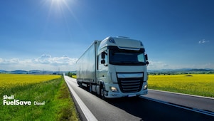 Lorry driving on a road next to a rapeseed field
