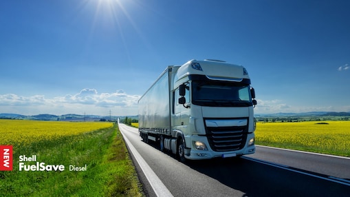 Lorry driving on a road next to a rapeseed field