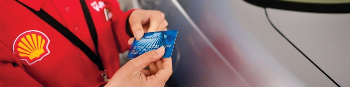 A woman paying for fuel at petrol station with Shell FuelCard