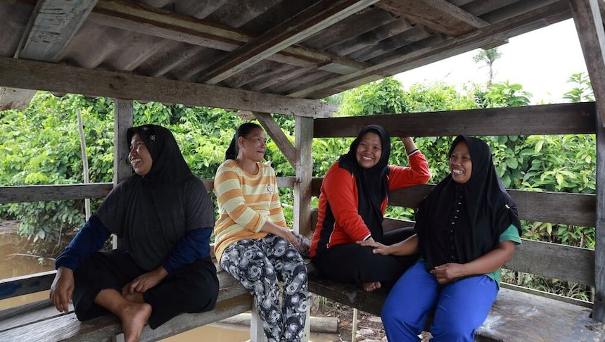 Female inspector discussing with engineer in car factory. Multi-ethnic male and female professionals are standing at car production line. They are in automotive industry.