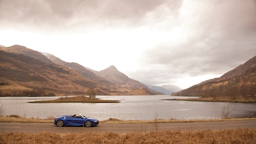 Car on the road by a mountain lake