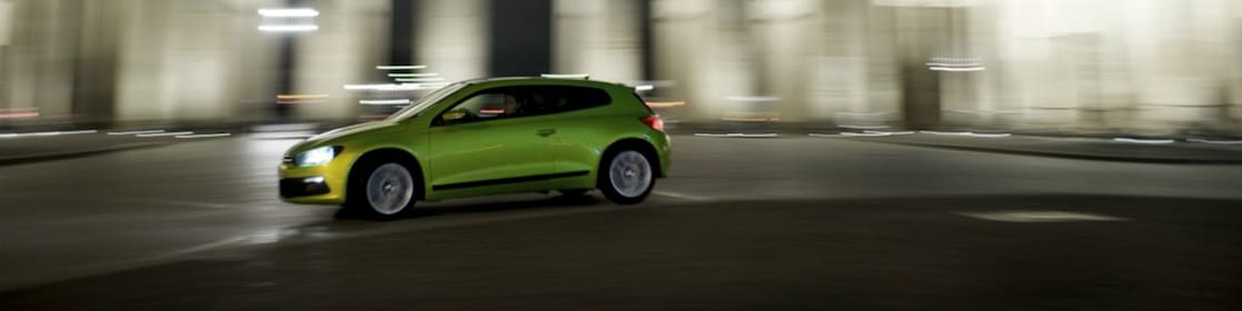 green car driving fast at night