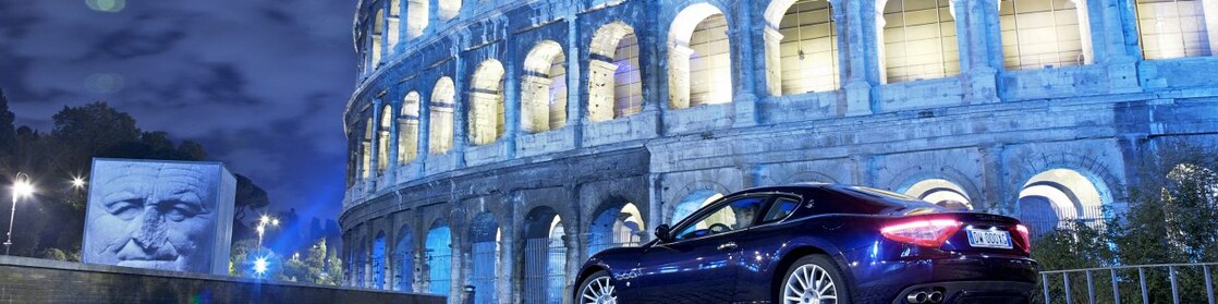 Car parked outside of the Colosseum in Rome at night