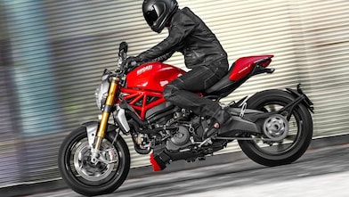 A man driving a motorcycle using extraordinary engine oil.