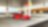 A red Ferrari sitting on a Shell station forecourt with a man leaning on a petrol pump