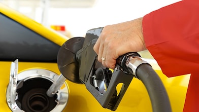 Person filling vehicle with fuel