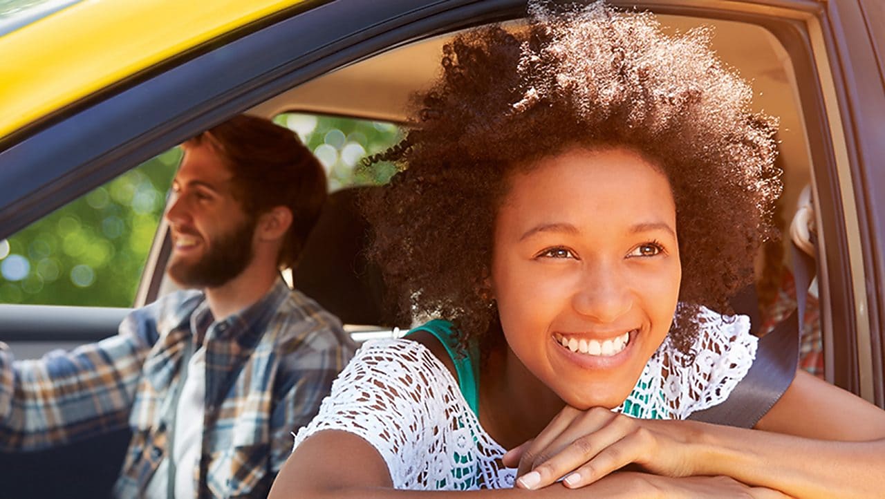 Shell recharge smiling girl looking out of yellow car window