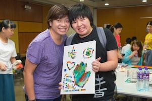 Student with special educational needs and parent took photo with painting.