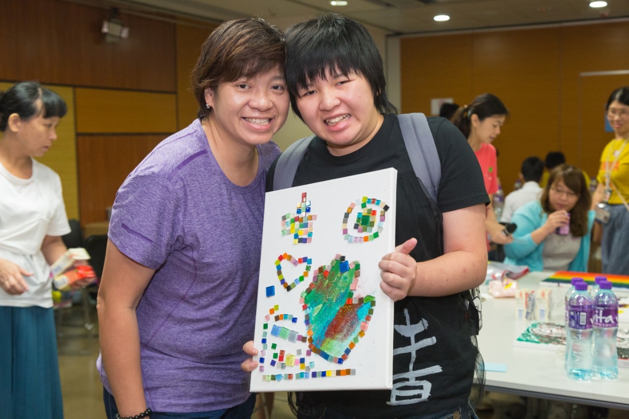 Student with special educational needs and parent took photo with painting.