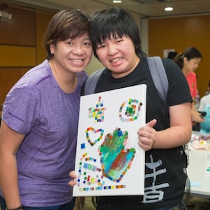 Student with special educational needs and parent took photo with painting.