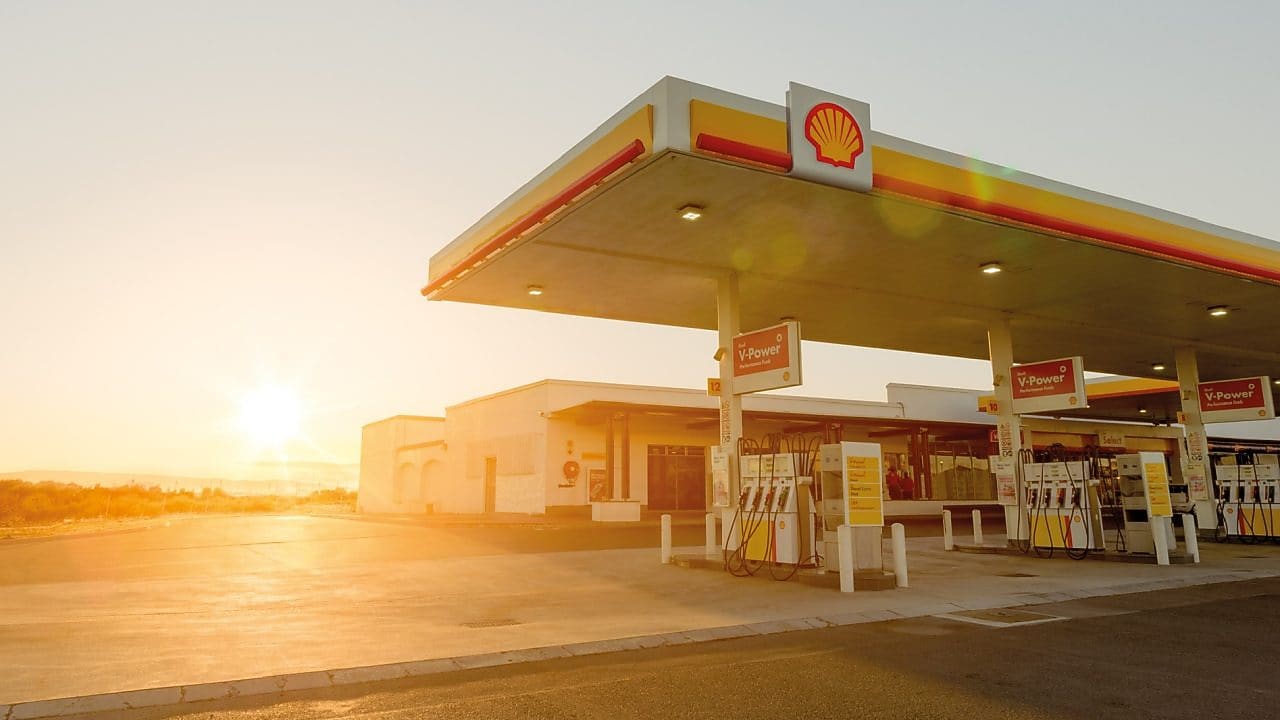 Sun rising behind a Shell station forecourt