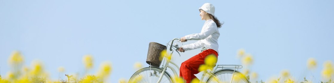 一個年輕女子騎車穿過一片夏天的田野