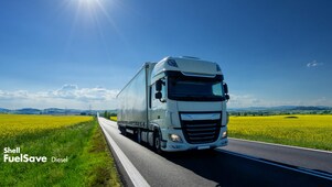 Lorry driving on a road next to a rapeseed field