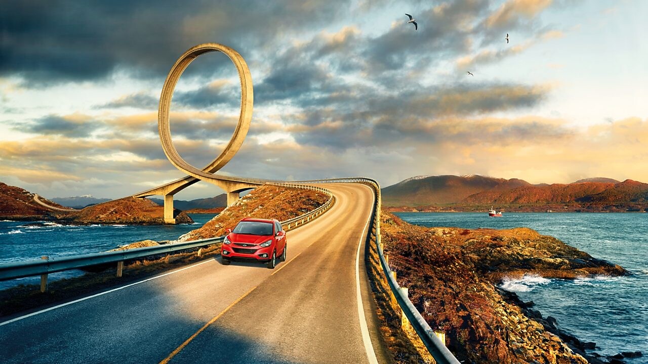 紅色汽車在河畔行駛