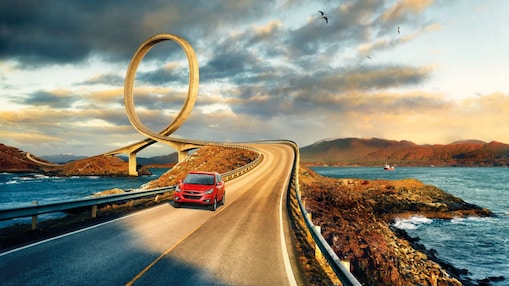 紅色汽車在河畔行駛