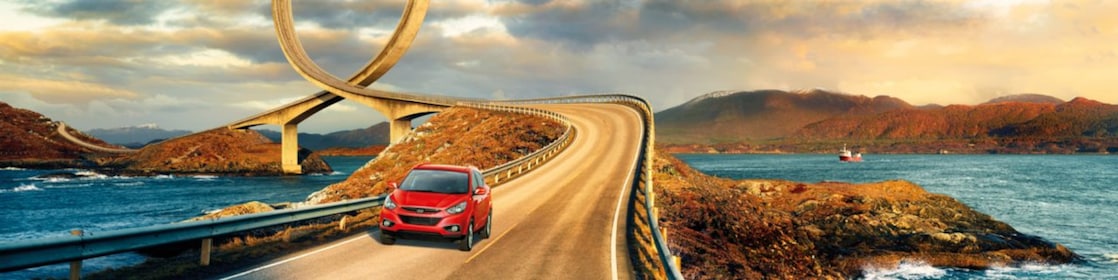 紅色汽車在河畔行駛