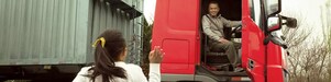 坐在紅色貨車駕駛艙內的男子正在向女兒揮手